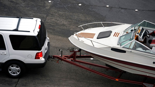 A boat trailer being pulled by an SUV.