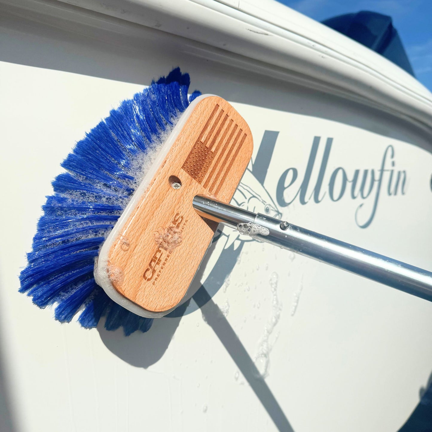 A boat cleaning brush with an American flag etched in the wooden head.