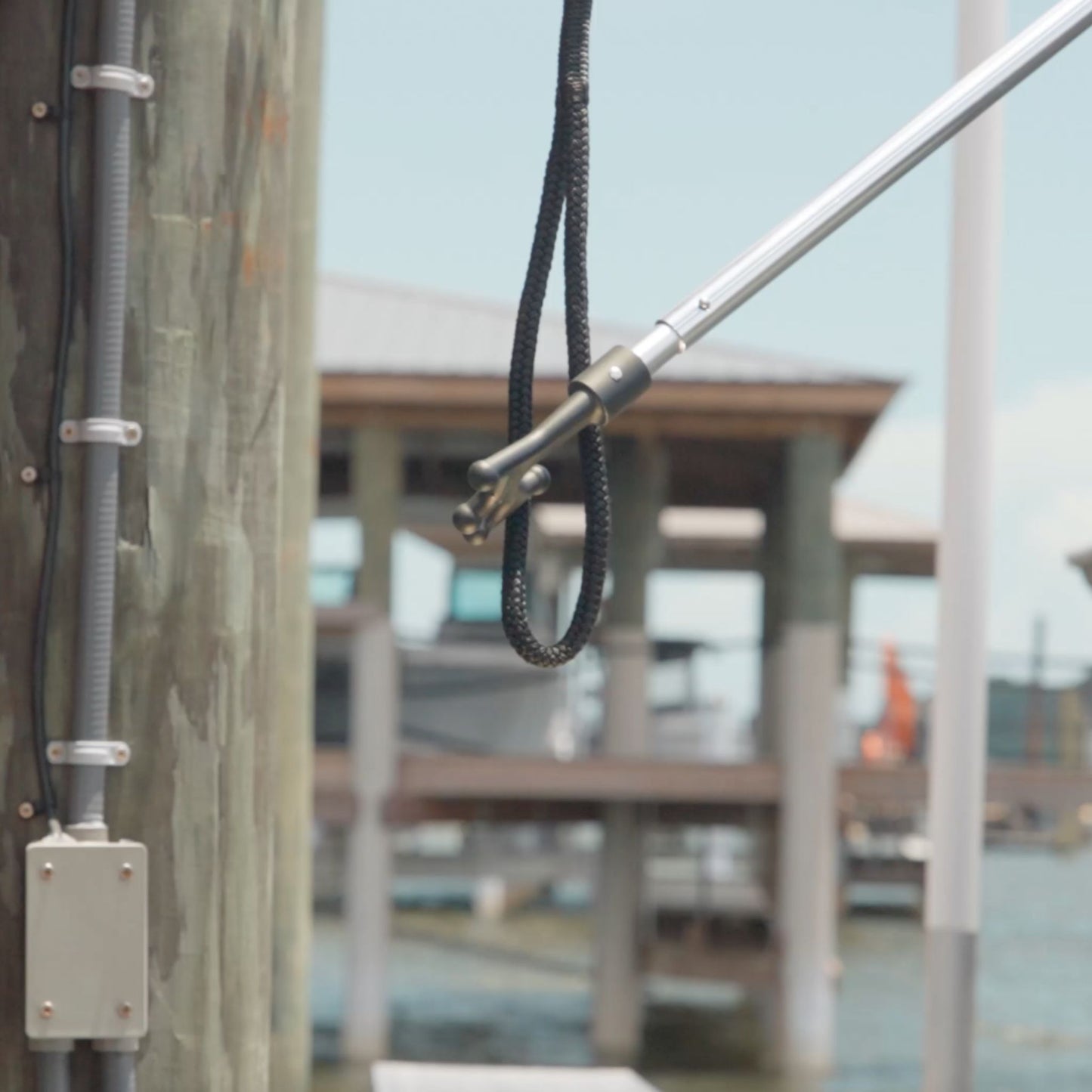 A boat hook grabbing the end of a dock line.
