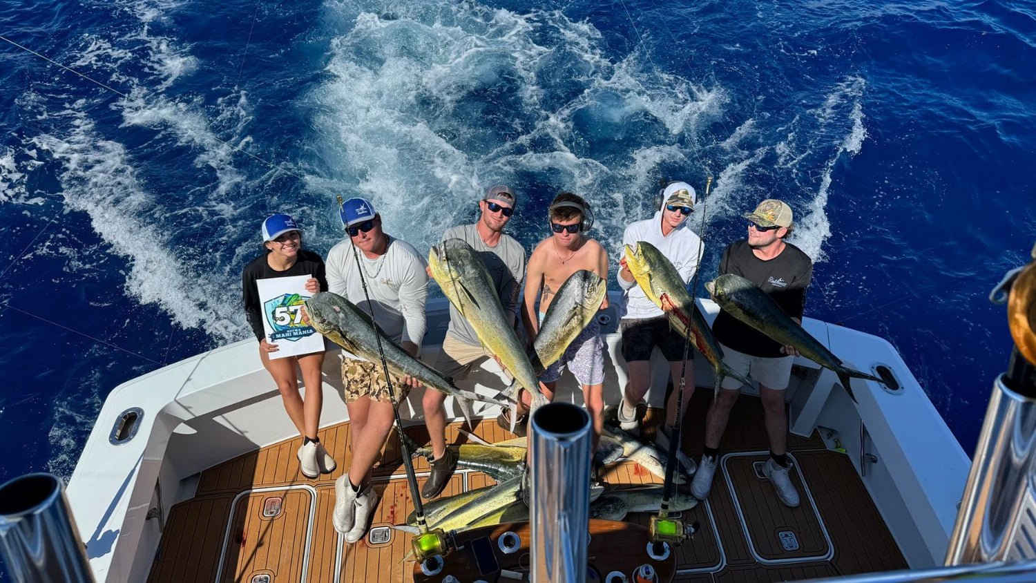 A fishing team shows off their mahi mahi dolphin catch.