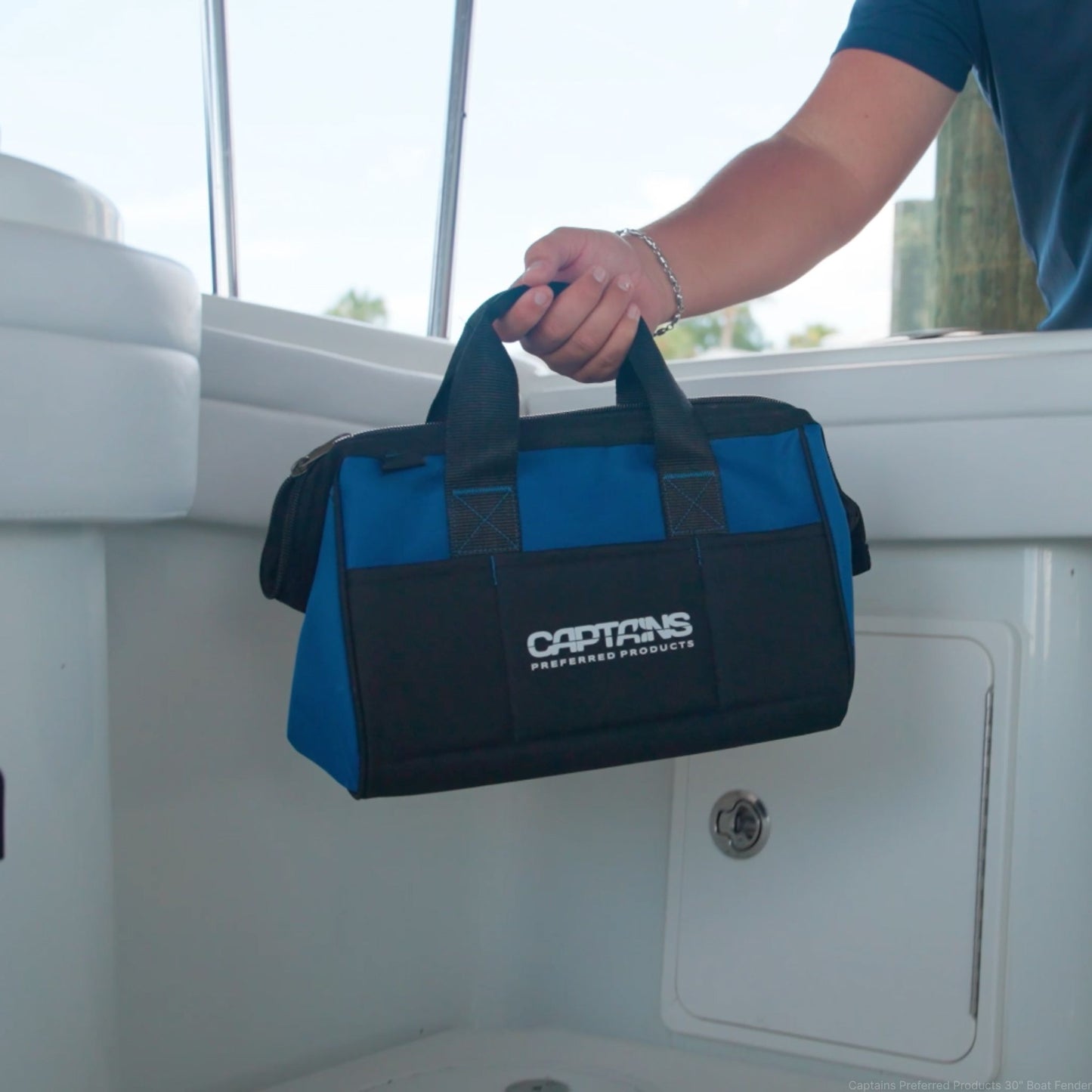 A man sets down his fishing weight lead bag inside the boat before a fishing trip.