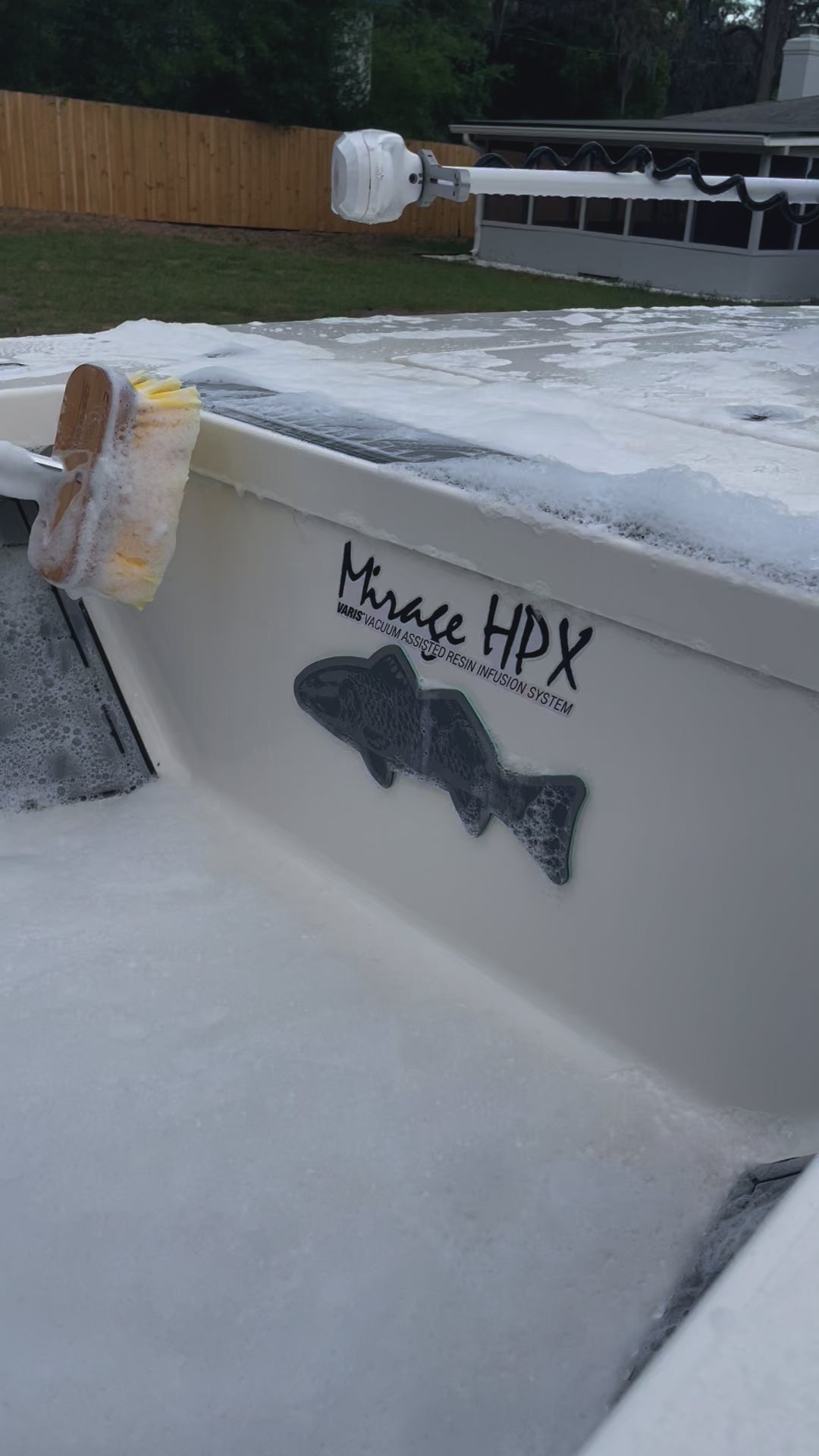 Using a yellow scrub brush to wash a fishing boat.