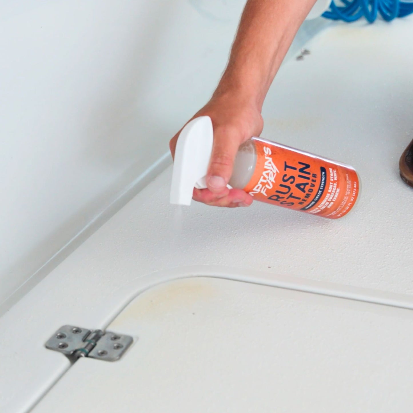 Spraying Captain's Fury Rust Remover Spray on a boat stain.