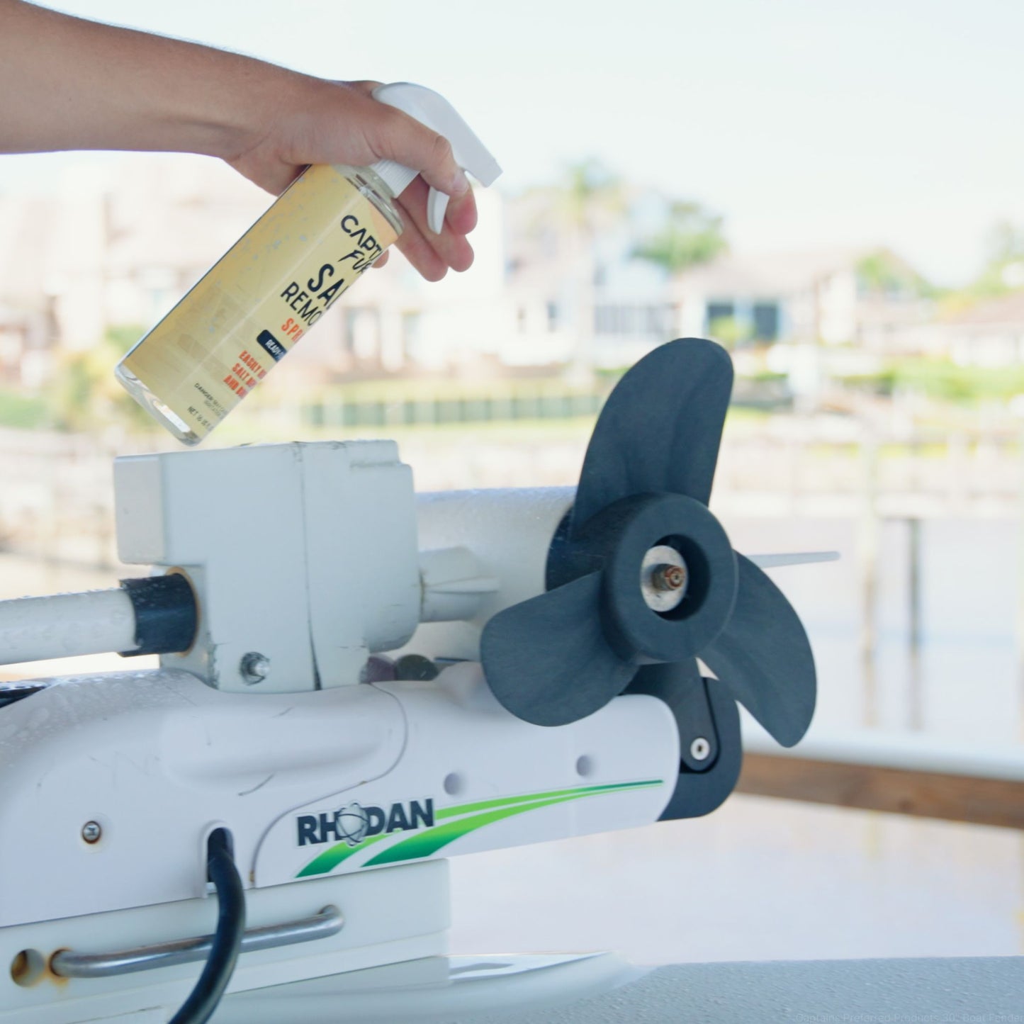 Using salt remover spray on a boat propeller to protect against salt damage.