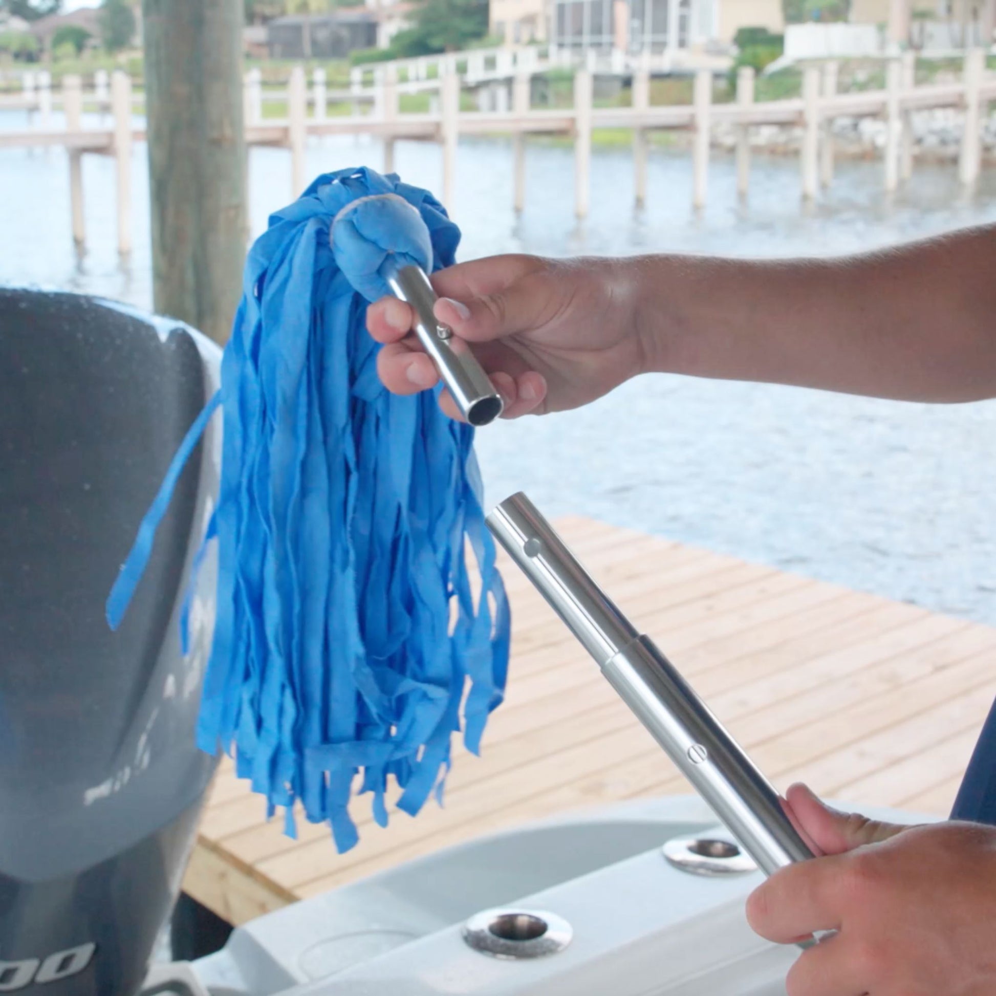 A blue shammy mop head being attached to a telescopic handle for boat drying.