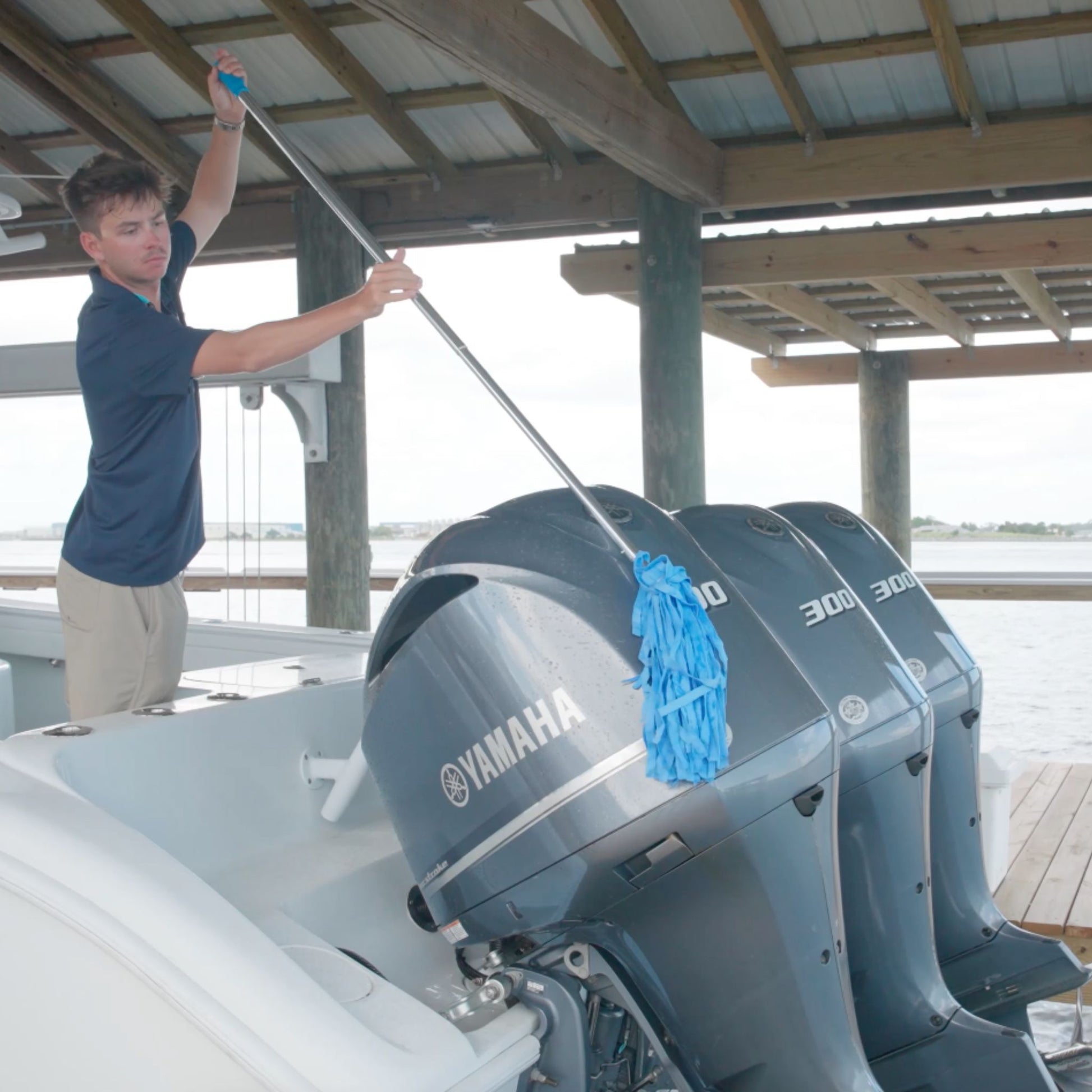 A shammy mop being used to dry motor cowlings after washing a boat.