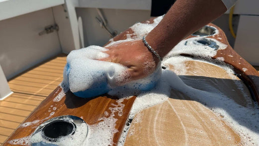 Washing the console of a boat with a soapy sponge.