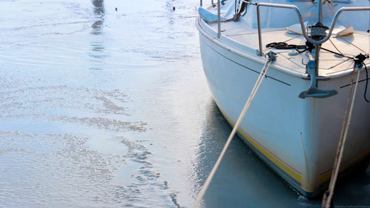 A boat sitting beached in the sand.