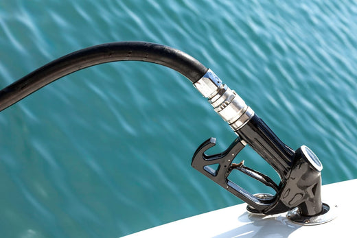 A gas pump filling up a boat's fuel tank.