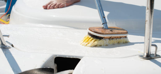 A yellow boat brush scrubbing the deck of a boat.