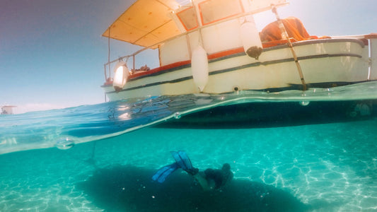 A diver explores under a pontoon boat.