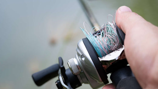 A webbed fishing line that has been reeled back onto the spool in a tangled mess.