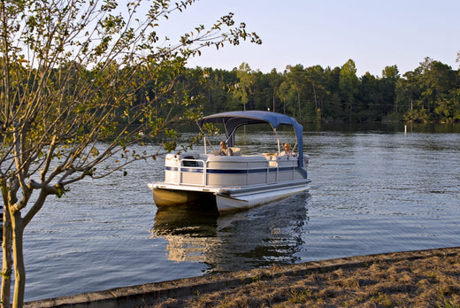 A pontoon boat sitting in a lake.