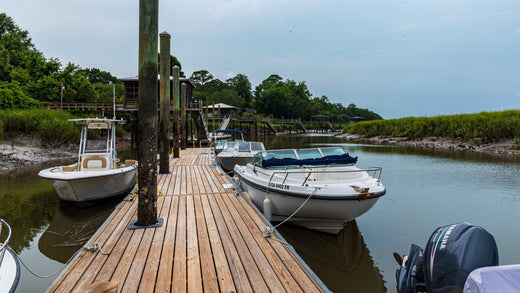 Small boats tied to two sides of a dock with dock lines.