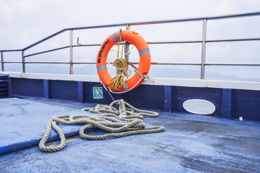 A lifesaver and dock line sitting on the deck of a ship.