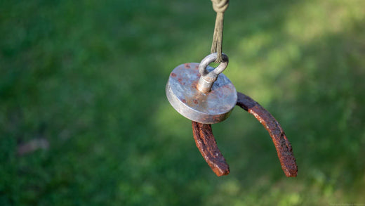 A magnet fishing line pulling up a rusty horseshoe.
