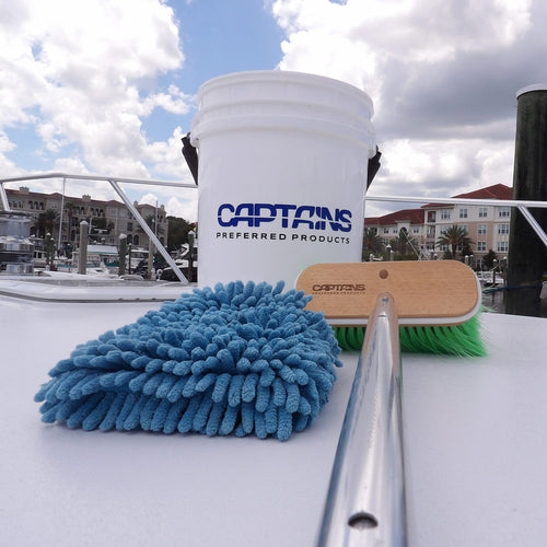 Captains Preferred Products' bucket wash mitt and brush sitting on a boat deck.