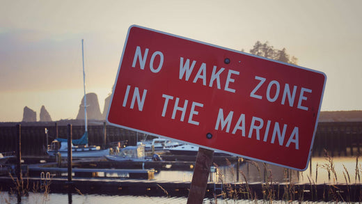 A sign declaring NO WAKE ZONE IN THE MARINA.