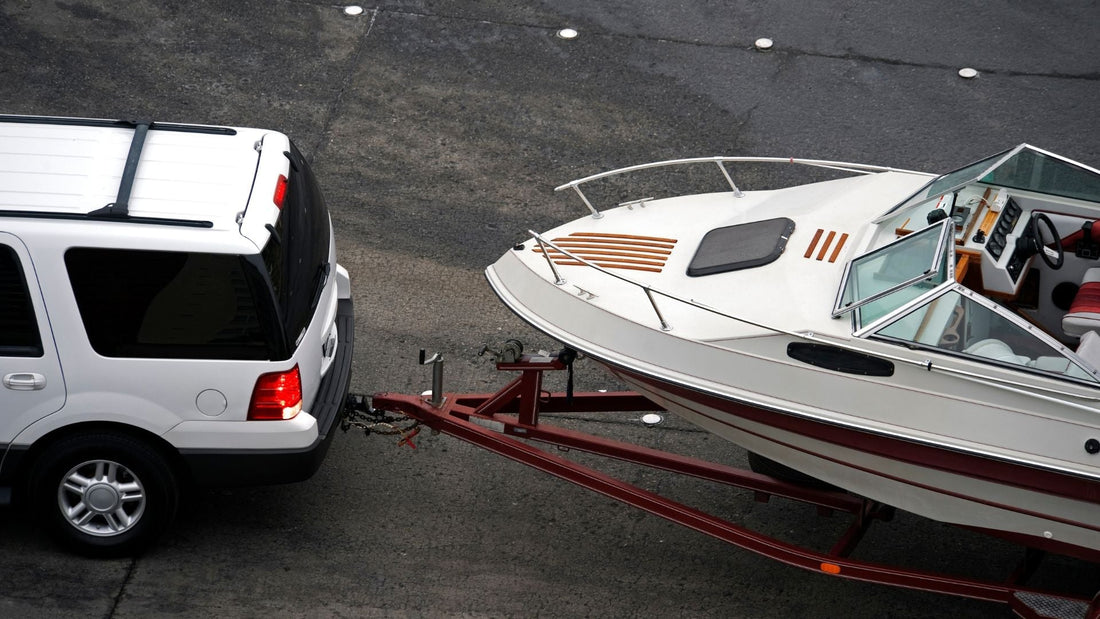 A boat trailer being pulled by an SUV.