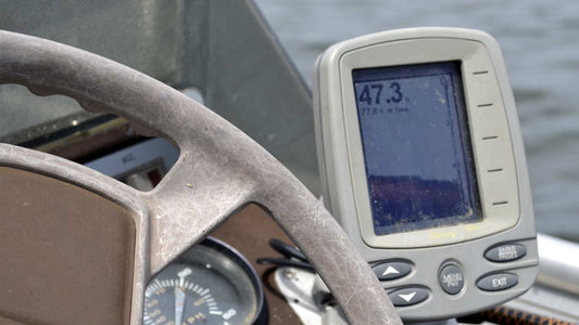 A fish finder transducer attached to a boat beside the control panel.