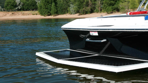 The transom on the back of a boat sitting in a serene lake setting.