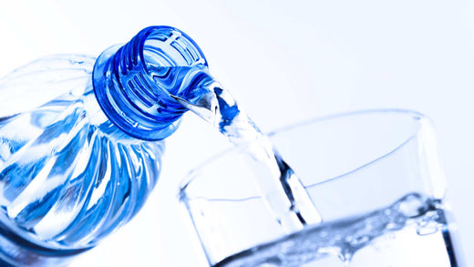 Fresh desalinated water being poured from a bottle into a glass.