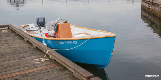 A small skiff boat tied to a dock.