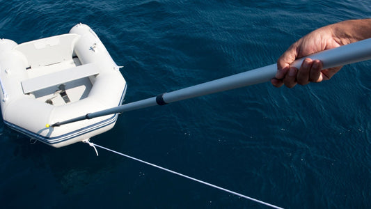 A telescopic boat hook is used to grab an inflatable boat from the water. 