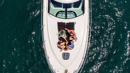 A top view of four friends sitting on the front of a boat in the ocean.