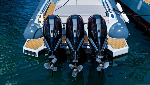 The back of a boat with three outboard motors to be winterized in preparation for the season.