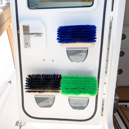 Three installed TidyBoat brush head organizers installed on a boat door, each holding a different color boat brush.