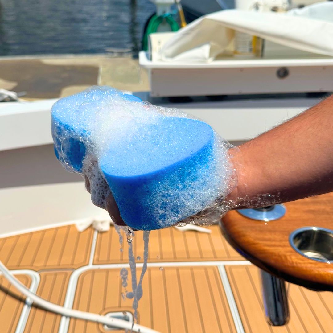 Captains' blue boat sponge full of soap and suds getting ready to wash a boat.