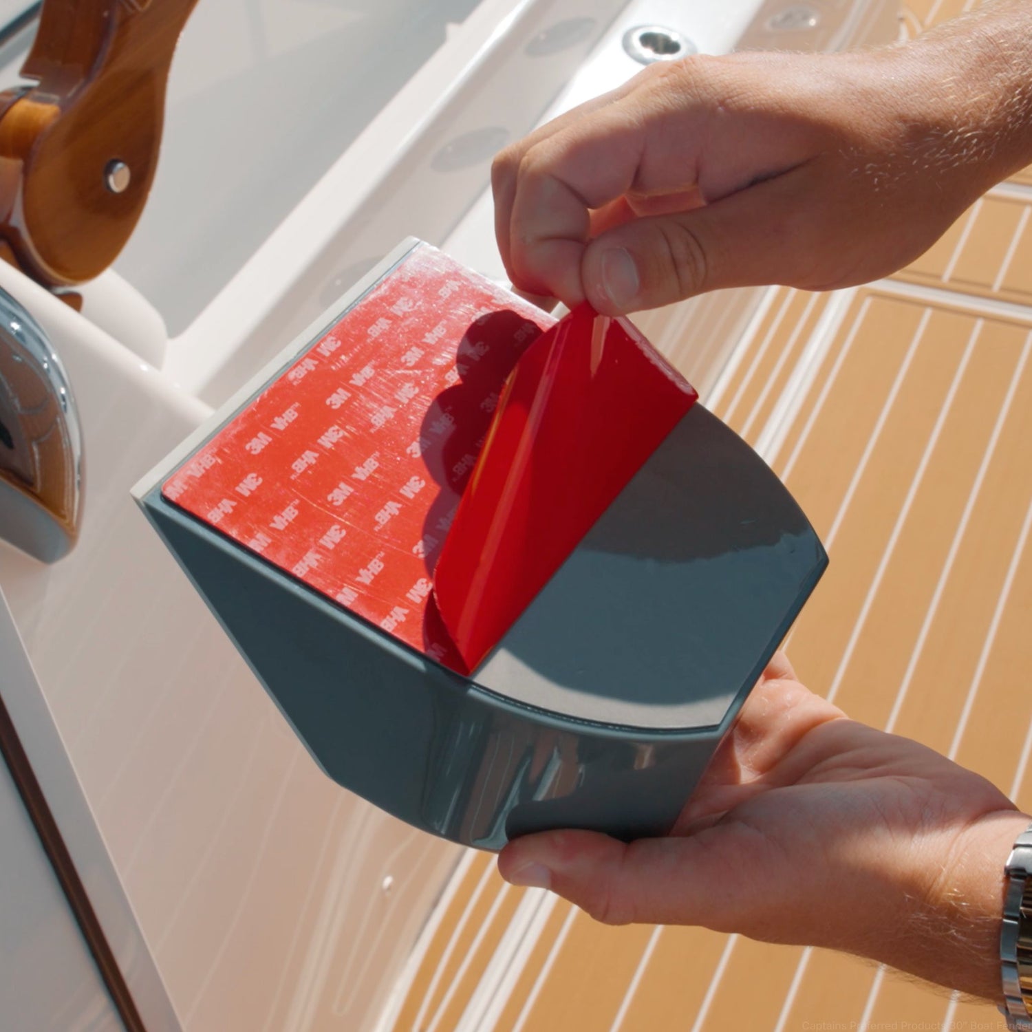 The 3M adhesive being peeled off the back of a TidyBoat Brush Head Organizer.
