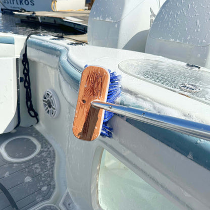 A soapy boat brush scrubbing a boat's gunwales.