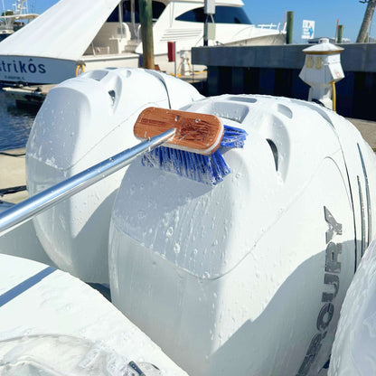 A blue boat brush scrubs engine cowlings.