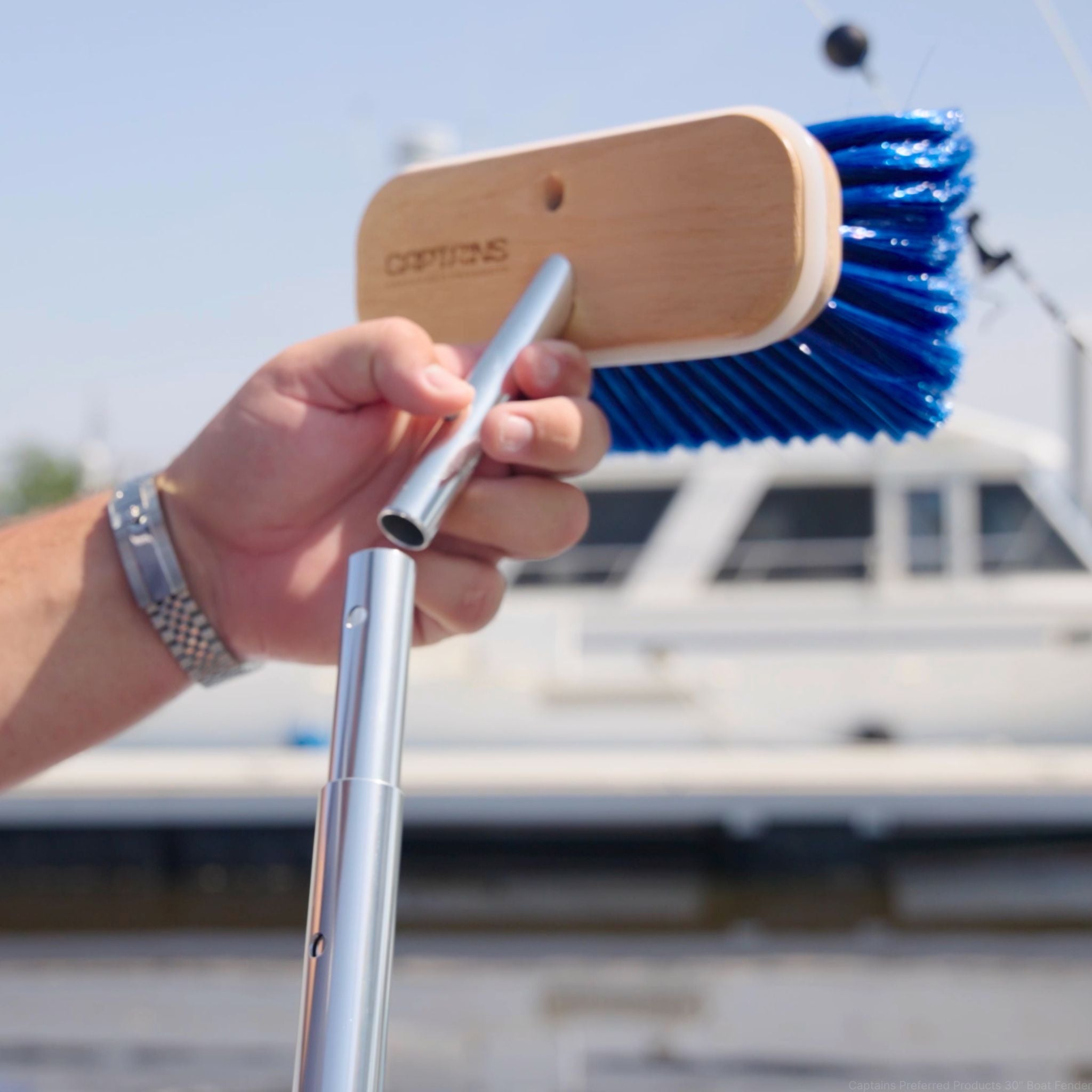 A boat brush head being attached to a telescopic handle for boat cleaning.