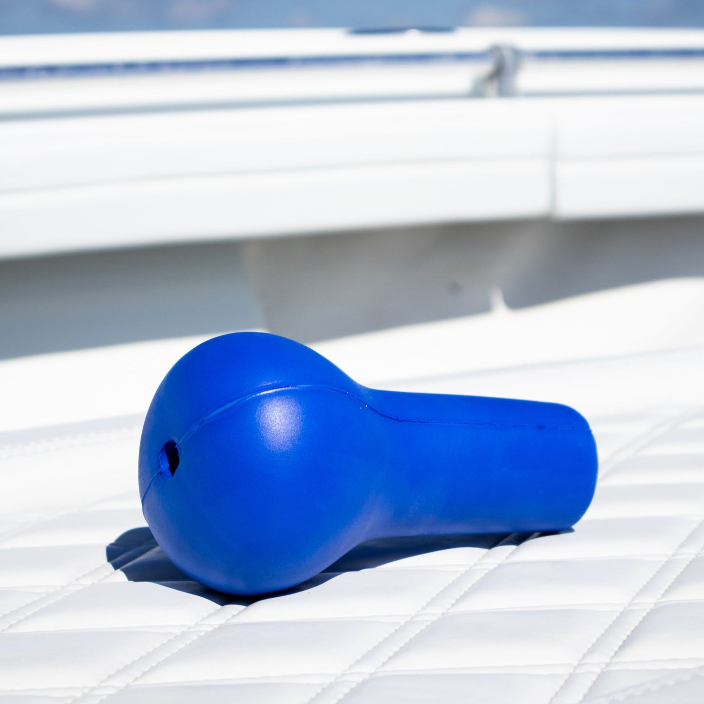 A blue fishing rod cushion sitting on a boat seat.
