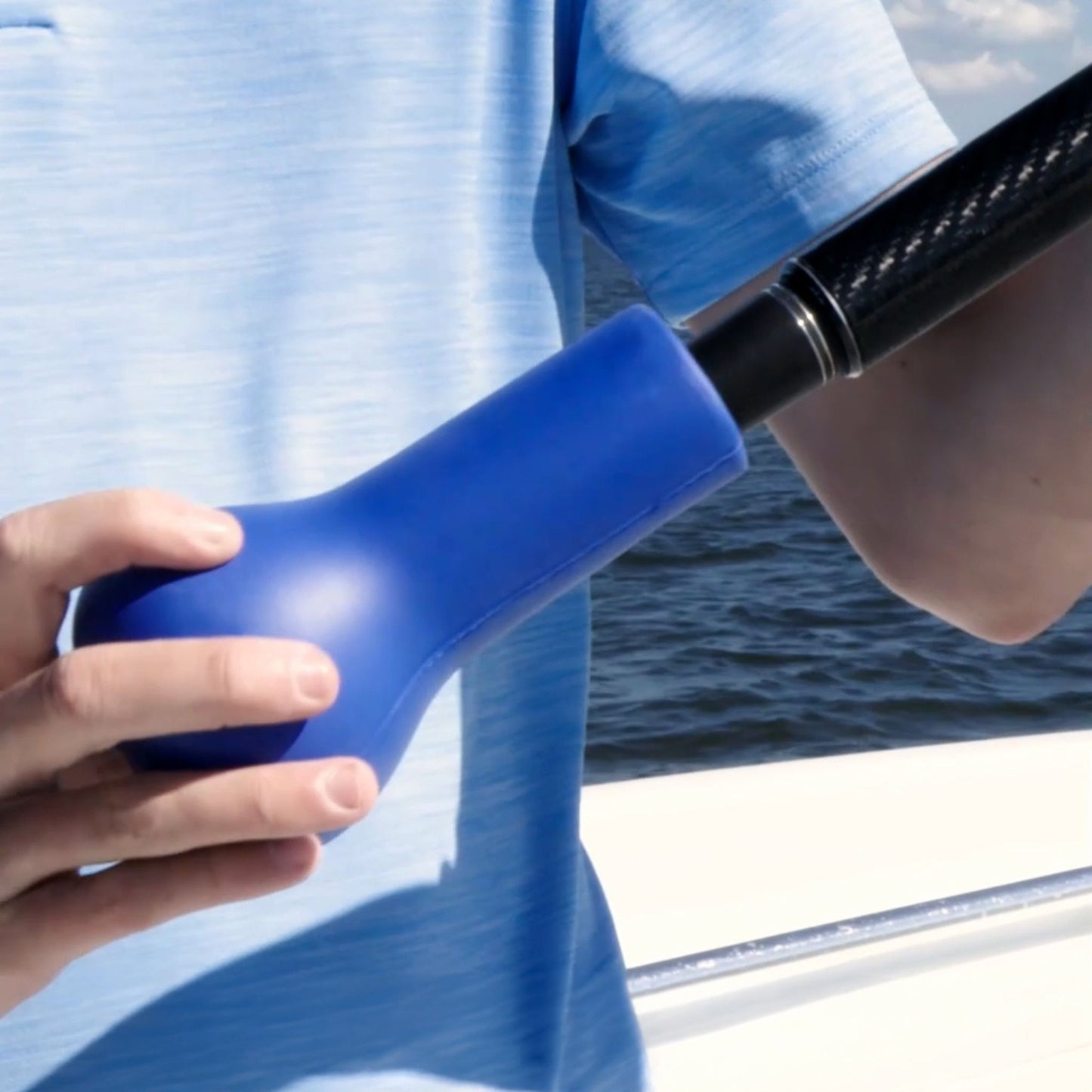 A fishing rod cushion being pushed onto the end of a fishing rod.