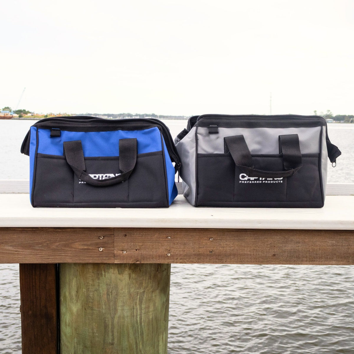 A blue and gray fishing weight lead bag sit on the edge of a dock.