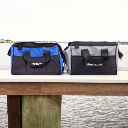 A blue and gray fishing weight lead bag sit on the edge of a dock.