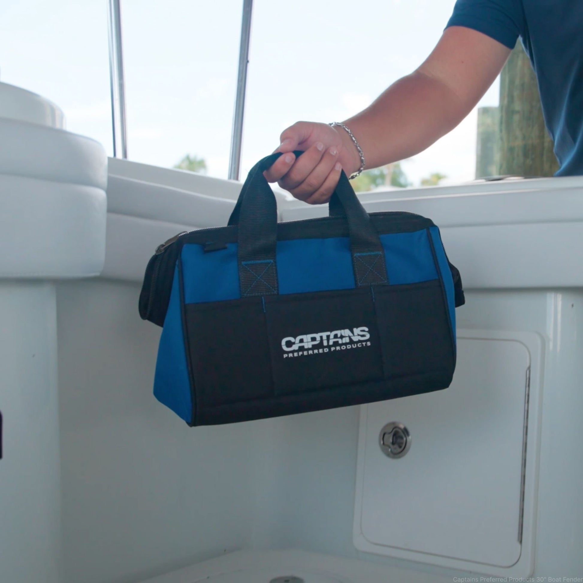 A man sets down his fishing weight lead bag inside the boat before a fishing trip.