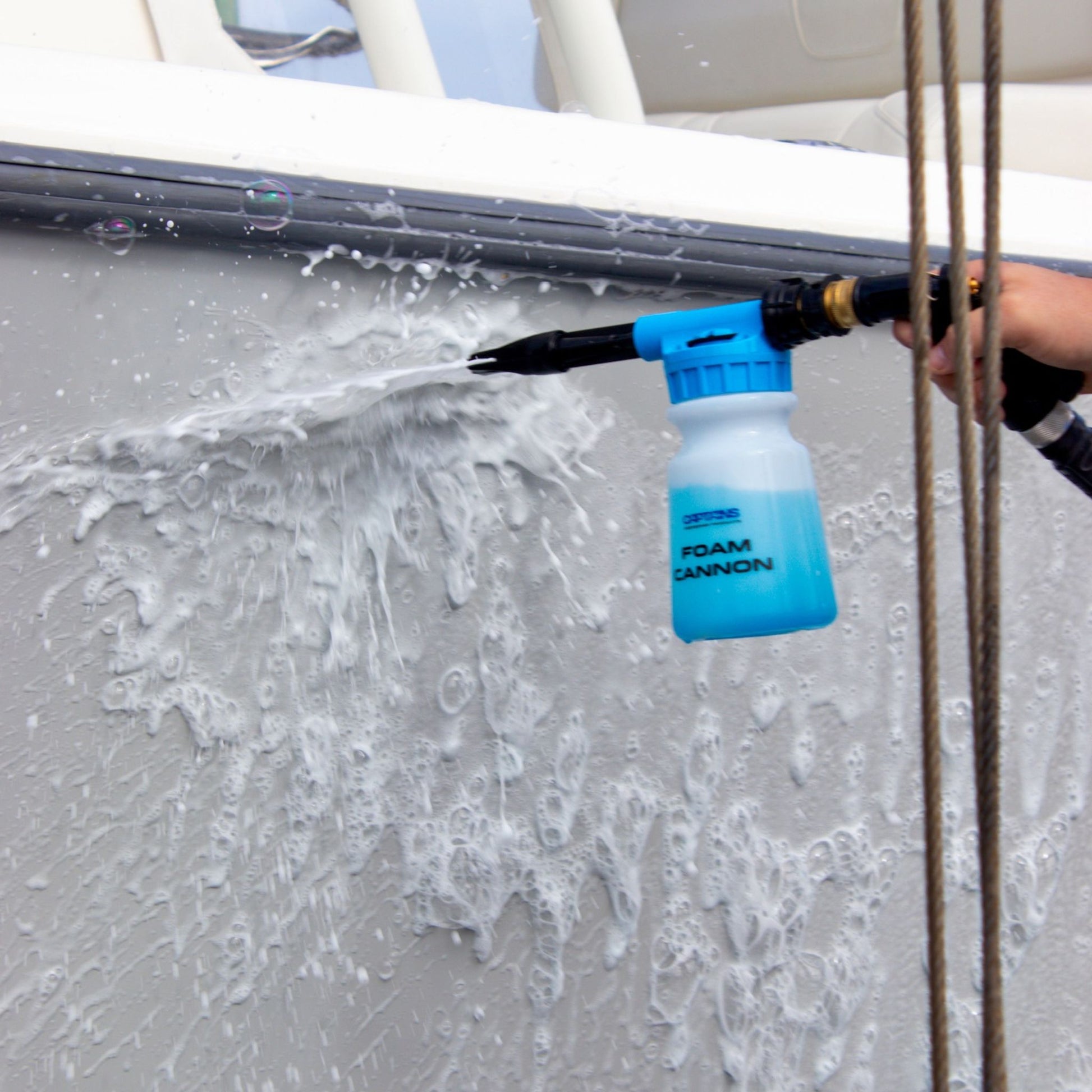 Foam cannon being used to clean a boat's exterior with lots of foam.