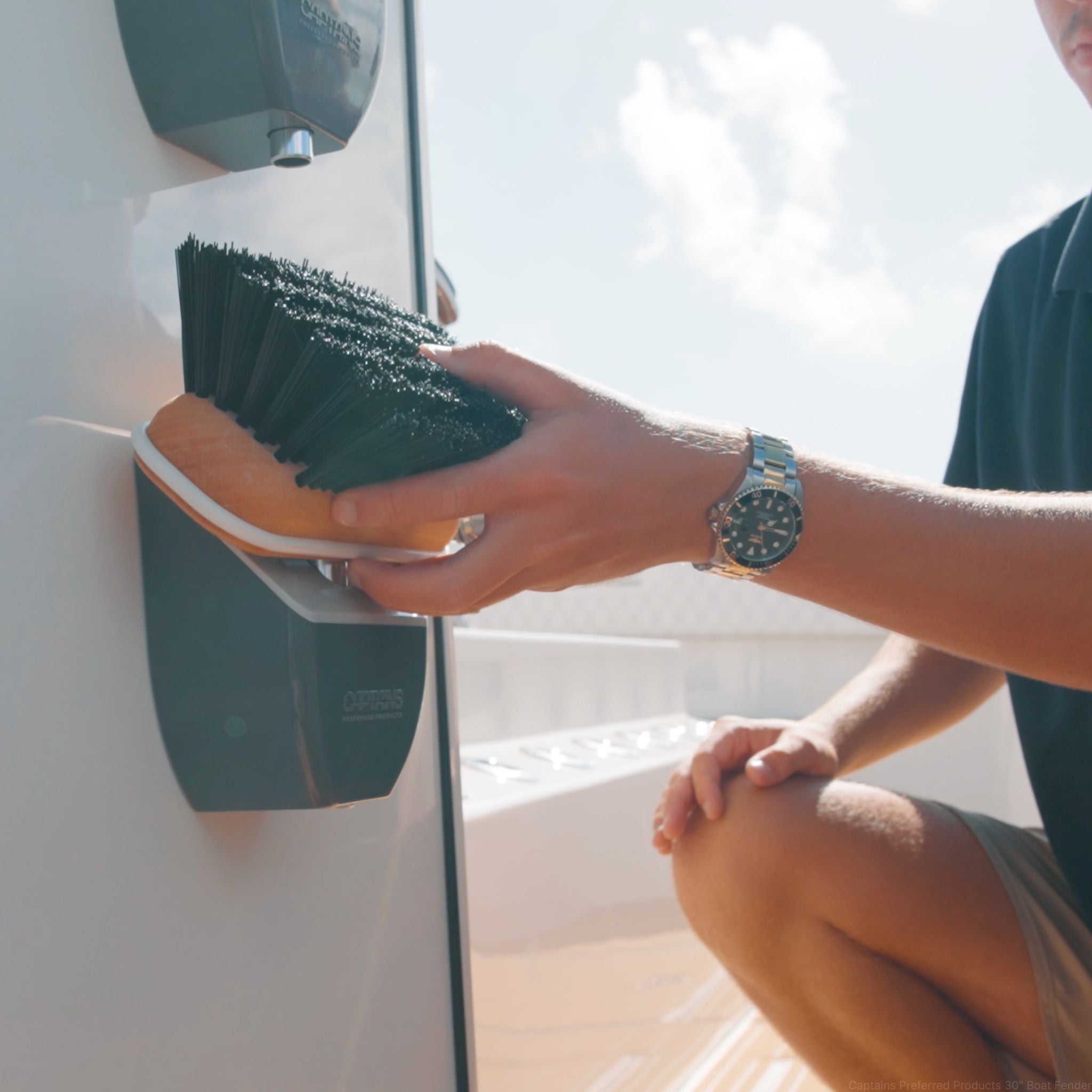A man reaches for a boat brush from a TidyBoat Brush Head Organizer.
