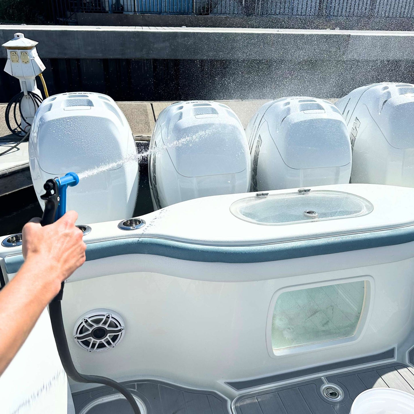 Captains' hose nozzle spraying down boat engine cowlings.