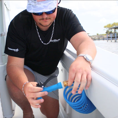 Man installing a washdown hose nozzle on a boat.