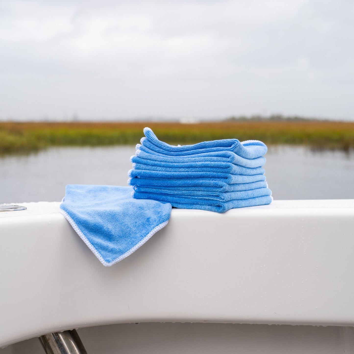 A stack of Captains Preferred Products microfiber rags sitting on the side of a boat.