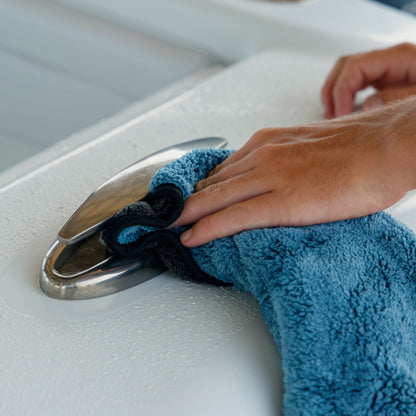 Plush microfiber drying towel soaking up water around a boat cleat.