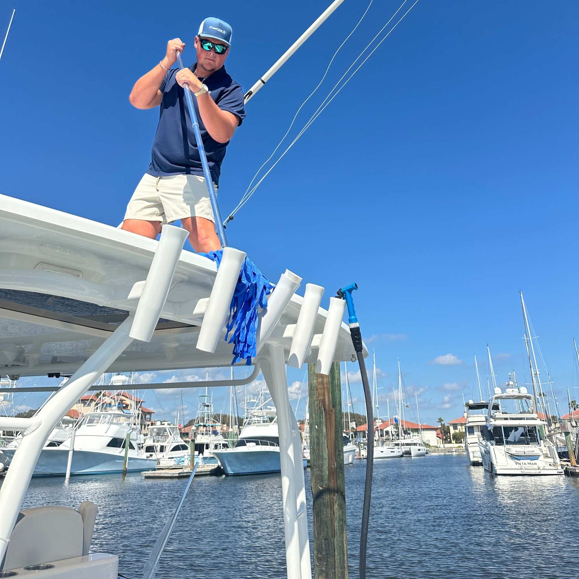 A boat cleaner using a chamois mop to dry a boat after washing.