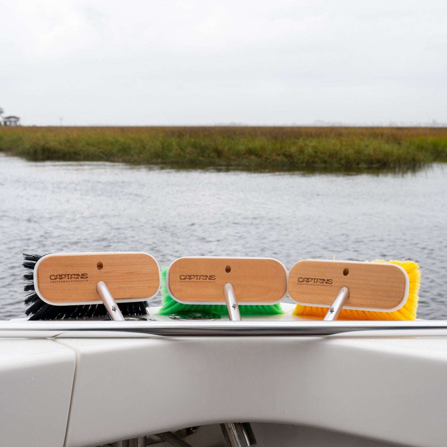 Boat cleaning brush kit with long handle on the transom of a boat.